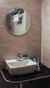 een badkamer met een witte wastafel en een spiegel bij Radhe Suites in Hyderabad