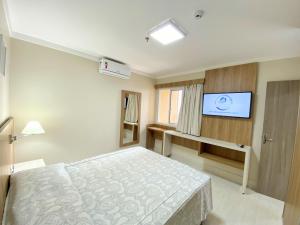 a bedroom with a bed and a flat screen tv at PIAZZA DIROMA - ACQUA PARK, SPLASH e SLIDE in Caldas Novas