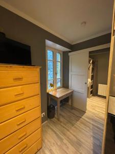 a bedroom with a desk and a dresser with a television at la Montagnette L ours T1 in Moutiers