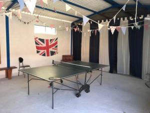 a ping pong table in a room with a flag at Villa Nardelli in Pozzuolo