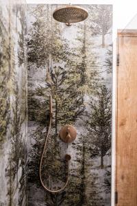 a shower in a bathroom with a wall mural at Såndgøld Alpine Glamping in Campo Tures