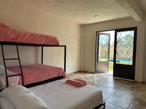 a bedroom with two bunk beds and a sliding glass door at Casa los ventanales in Chiconcuac
