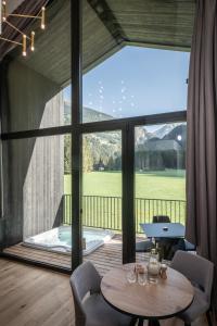 a room with a table and a large window with a tub at Såndgøld Alpine Glamping in Campo Tures