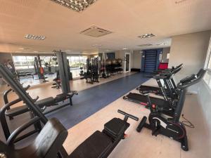 einen Fitnessraum mit mehreren Laufbändern und Heimtrainern in der Unterkunft Apartamento no Jardim Goiás em Goiânia in Goiânia