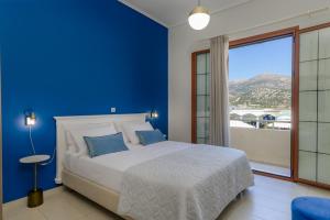 a blue bedroom with a bed and a large window at Centro Y Mar! Central Penthouse with Terrace! in Argostoli