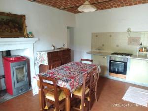 a kitchen with a table and a kitchen with a stove at Casale immerso nel bosco a Casalborgone con piscina all'aperto in Casalborgone