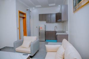 Mama's Favourite Apartments في كيغالي: غرفة معيشة مع أريكة ومطبخ +5 صور