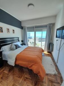 a bedroom with a large bed and a large window at Jorge ll in Mar del Plata