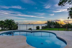 Merritt Island的住宿－Tropical Riverfront Paradise - Gorgeous Sunset Views，享有水景的游泳池