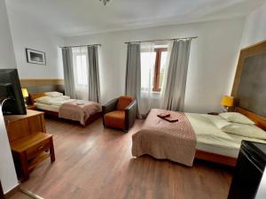 a hotel room with two beds and a chair at Willa Brancon in Babimost