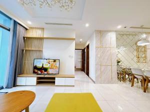 uma sala de estar com uma televisão na parede em Luxury Vinhomes Central Park (Cozy Apartment) em Ho Chi Minh