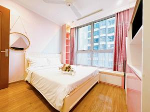 um pequeno quarto com uma cama e uma grande janela em Luxury Vinhomes Central Park (Cozy Apartment) em Ho Chi Minh