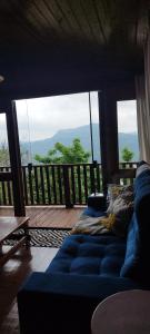 a living room with a blue couch in front of a balcony at Cabana Alto do Monte in Gramado