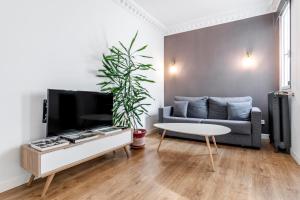 Home Suite Home Gran Via في مدريد: غرفة معيشة مع أريكة وطاولة