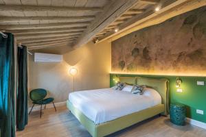 1 dormitorio con 1 cama y una pintura en la pared en Blossoms of Siena, en Siena