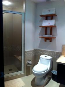 La salle de bains est pourvue de toilettes et d'une douche en verre. dans l'établissement Bay View Marina- Monthly rentals special at Tripintravel, à Ixtapa