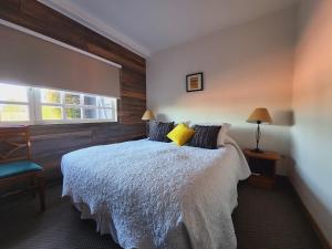 Schlafzimmer mit einem Bett und einem Fenster in der Unterkunft Hotel Geronimo in Pucón