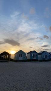 a row of houses on the beach at sunset at Stunning 2 bed, water front Poole Quay Apartment. in Hamworthy