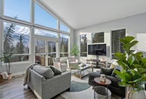 uma sala de estar com muitas janelas em Cozy Private Hot Tub, Luxe Views! Shiloh&harmony em Eagle River