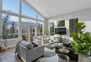 un soggiorno con molte finestre di Cozy Private Hot Tub, Luxe Views! Shiloh&harmony a Eagle River