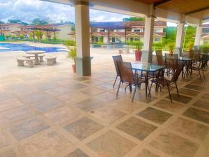 a patio with tables and chairs and a pool at Jacarandas #16, 5 min tamarindo in Villarreal