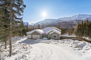 una casa è coperta di neve in montagna di Cozy Private Hot Tub, Luxe Views! Shiloh&harmony a Eagle River