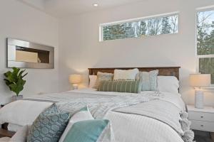 een witte slaapkamer met een groot bed en een raam bij Cozy Private Hot Tub, Luxe Views! Shiloh&harmony in Eagle River