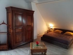a bedroom with a bed and a large wooden cabinet at La maison de Véro in Wittisheim