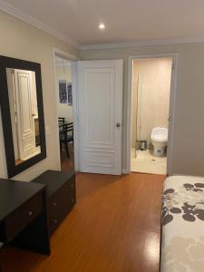a bedroom with a bed and a door to a bathroom at Fontana: Location + Pool in Quito