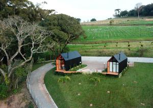 two cottages in a field next to a road at Alta Vista Cabanas in Garibaldi