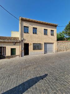 a building with a cobblestone driveway in front of it at Casa Telares Ávila in Ávila
