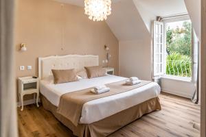 迪南Demeures & Châteaux - Hôtel de la porte Saint-Malo - DINAN的一间带大床和大窗户的卧室