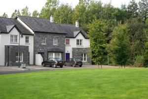 a house with two cars parked in front of it at Bunratty Holiday Homes in Bunratty