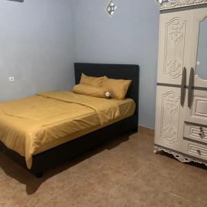 a bedroom with a bed and a dresser in the corner at DEWI HOTEL in Kuta Lombok