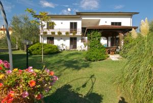una gran casa blanca con un patio con flores en Agriturismo Saralisa, en Montecarlo