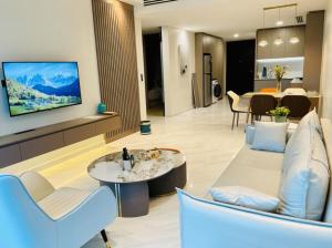 a living room with a couch and a tv on a wall at Eaton Suites KLCC Kuala Lumpur in Kuala Lumpur