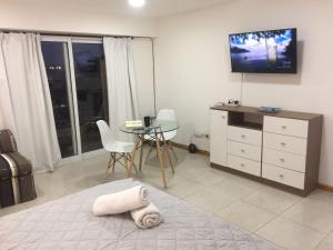 sala de estar con TV, mesa y cama en Alquiler turistico en San Miguel de Tucumán