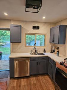 a kitchen with gray cabinets and a sink at Bearfoot Bungalow in Sauble Beach