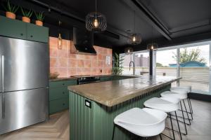 une cuisine avec des placards verts et des tabourets de bar blancs dans l'établissement Heaven's Garden / / Luxury penthouse downtown, à Québec