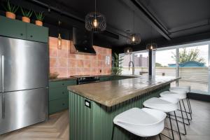 a kitchen with green cabinets and white bar stools at Heaven's Garden / / Luxury penthouse downtown in Quebec City
