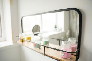 a mirror with jars on a shelf in a bathroom at Sara’s Apartment in Seaham