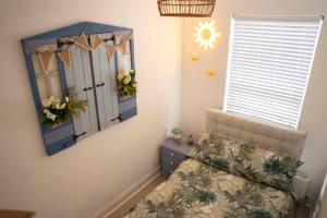 a bedroom with a mirror and a chair and a window at Sara’s Apartment in Seaham