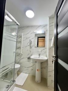 y baño con lavabo y ducha. en Hotel Marina 2, en Bucarest