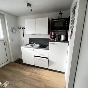 グラール・ミューリッツにあるFerienwohnung Dünengrasのシンクと電子レンジ付きの小さなキッチン