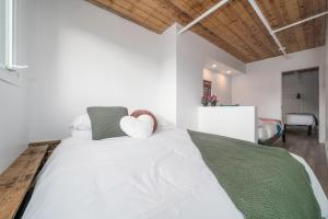 a bedroom with a white bed with two heart pillows at Heaven's Garden / / Luxury penthouse downtown in Quebec City