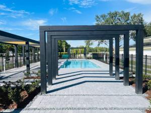 a pavilion with a pool in a yard at Brand New Townhouse, min from Disney in Kissimmee