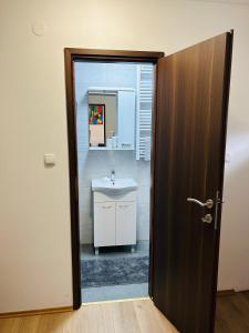 an open door to a bathroom with a sink at Apartment In Time in Sesvete