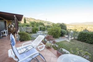 eine Terrasse mit 2 Stühlen, einem Tisch und einem Garten in der Unterkunft Villetta Bel Giardino in Marina di Campo