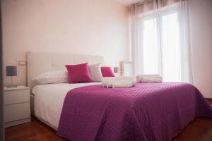 ein Schlafzimmer mit einem großen Bett mit einer lila Decke in der Unterkunft Silver Dream House in San Quirico dʼOrcia