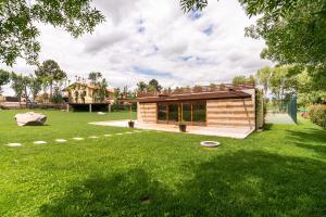 een klein huis in een tuin met een groen gazon bij Casa do Espigueiro in Chaves